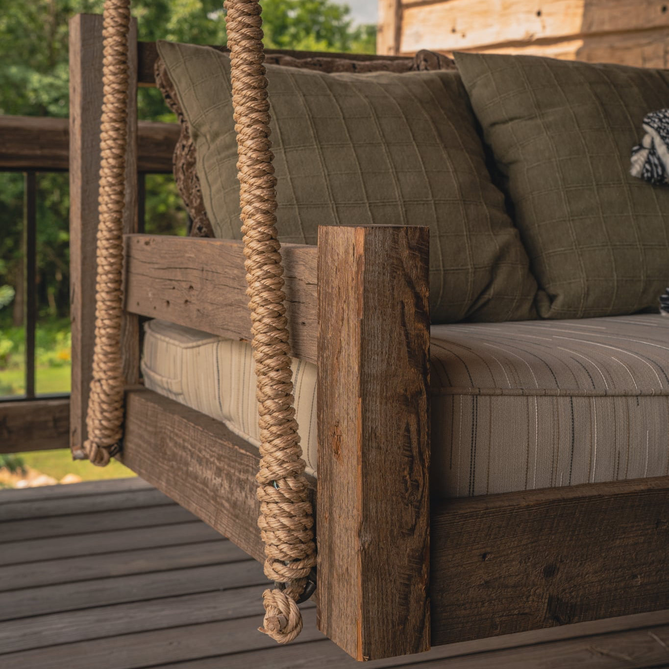 Lakosky reclaimed wood porch swing bed with forged metal balusters and patterned outdoor pillows